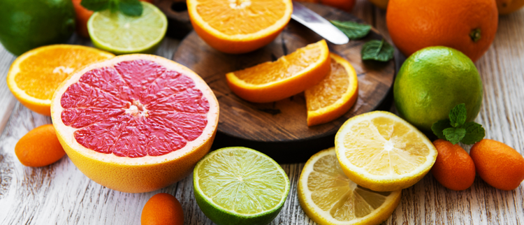 Blog of What Are the Best Supplements for Immunity? which have image Sliced grapefruit, lime, lemon, and oranges arranged on a wooden table with kumquats and mint leaves.